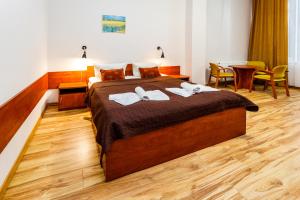 1 dormitorio con 1 cama grande y toallas. en Villa Antares I & II en Świnoujście