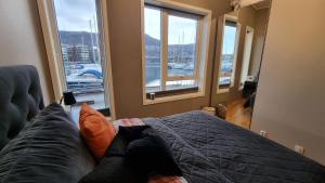 1 dormitorio con 1 cama y vistas al puerto en Byleilighet i sjøkanten m terrasse en Bergen