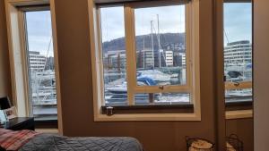 1 dormitorio con ventana y vistas al puerto deportivo en Byleilighet i sjøkanten m terrasse en Bergen