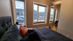 a bedroom with a bed with a view of a marina at Byleilighet i sjøkanten m terrasse in Bergen