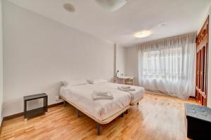 - une chambre blanche avec un lit et une fenêtre dans l'établissement Apartamento el Parque by Clabao, à Logroño