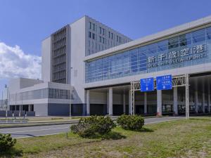 a large building with blue signs in front of it at Portom International Hokkaido in Chitose