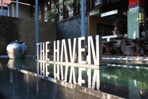 a sign in front of a building with a pool at THE HAVEN Bali Seminyak in Seminyak