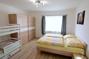 a bedroom with a bed and a dresser and a window at Apartmány Smrkový vrch in Vaclavov u Bruntalu