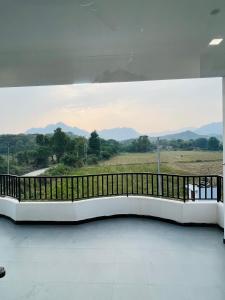 um quarto com uma varanda com vista para as montanhas em Govardhan villas Guest House & Farm Stay em Bijāpur