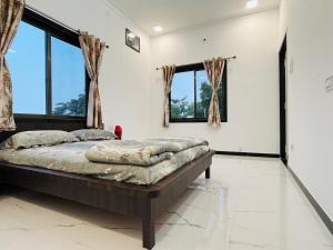 um quarto com uma cama num quarto com janelas em Govardhan villas Guest House & Farm Stay em Bijāpur