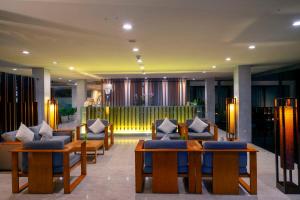 a hotel lobby with couches and tables with pillows at THE HAVEN Bali Seminyak in Seminyak