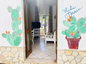ein Wohnzimmer mit einem Kaktus-Wandbild in der Unterkunft Lulù Marin Casa Vacanze Praia a Mare in Praia a Mare