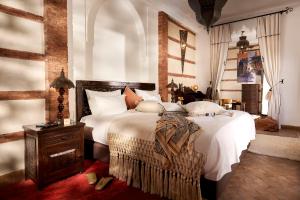 1 dormitorio con 1 cama grande con sábanas blancas en Riad Dar Amanza en exclusivité avec 4 chambres au coeur de la médina, en Marrakech