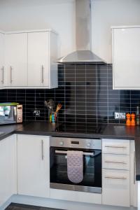 a kitchen with a black and white stove top oven at No. 82 Grade II Listed Norwich City Centre Flat in Norwich
