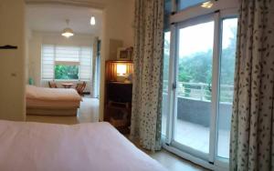 sypialnia z łóżkiem i przesuwnymi szklanymi drzwiami w obiekcie Rachels Inn w mieście Tongluo