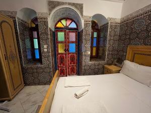 Schlafzimmer mit einem Bett und einer roten Tür in der Unterkunft Riad Fes Unique in Fès