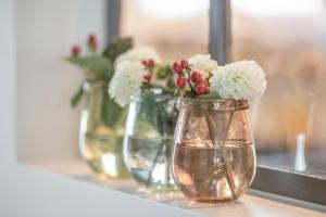 Eine Vase mit Blumen im Regal. in der Unterkunft Ferienhaus Daheim in Sankt Peter