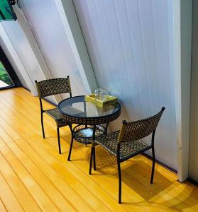 un tavolo in vetro con due sedie e un tavolo con bevande sopra di Sean Sawat Resort 2 