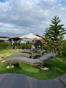 una panchina nell'erba con una persona sullo sfondo di Sean Sawat Resort 2 