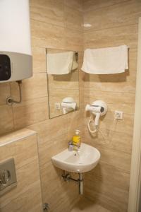 a bathroom with a sink and a phone on the wall at Motel Zeta Lux in Mitrovići