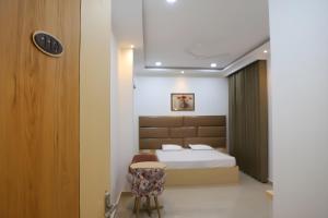 ein Schlafzimmer mit einem Bett und einem Stuhl in der Unterkunft Radha Madhav Hotel & Banquet in Palwal