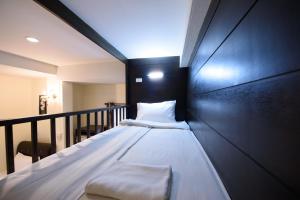 a bed in a room with a black wall at Chanaplace Lanna in Chiang Mai