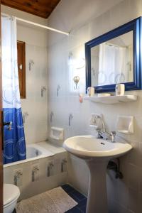 a bathroom with a sink and a mirror and a tub at Belle Epoque - Holiday Home in Aegina Town