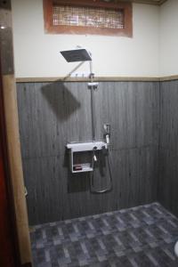 a shower in a bathroom with a metal wall at Gili Tempoe in Gili Trawangan