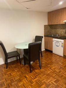 une cuisine avec une table, deux chaises et un comptoir dans l'établissement Excellent location,budget stay Darling Harbour, à Sydney