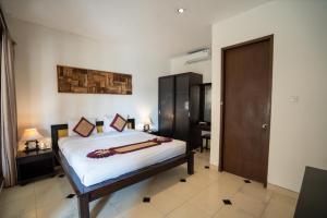 a bedroom with a bed and a desk and a door at Baleka Resort & Spa in Legian