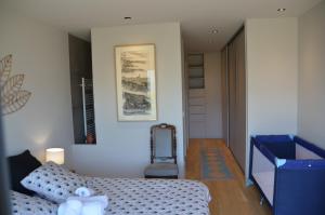 a bedroom with a bed and a chair in it at Le Panorama du Lac in Sévrier