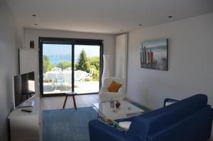 a living room with a blue couch and a table at Le Panorama du Lac in Sévrier