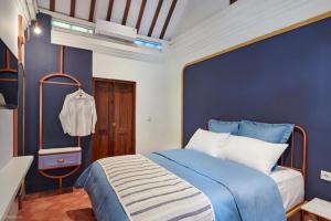 niebieska sypialnia z łóżkiem i niebieską ścianą w obiekcie Chendela Yogyakarta w mieście Yogyakarta