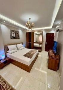 Riverfront Apartment 1 في القاهرة: غرفة نوم فيها سرير وتلفزيون