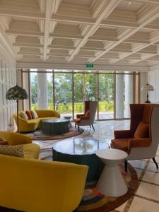 a living room with yellow chairs and tables at La Phan Phu Quoc, Hillside Apartment in Phu Quoc