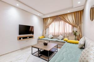 sala de estar con sofá y TV en Appartement résidence Marrakech haut standing piscine, en Marrakech