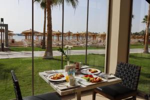 a table with plates of food and a view of a resort at Xanadu Makadi Bay - High Class All Inclusive in Hurghada