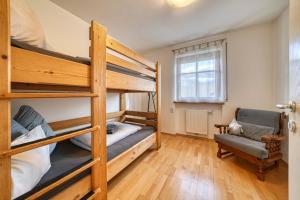 a bedroom with two bunk beds and a chair at FaWa Apartments "Family" in Brunico