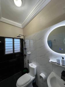 a bathroom with a toilet and a sink and a mirror at MonGite in Cotonou