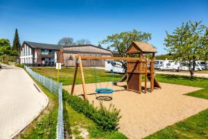 a playground with a swing set in a park at Hangar 19 Superior Apartment mit Seeblick H5W2 in Schwerin
