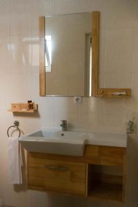 a bathroom with a white sink and a mirror at Bela Sombra in Vila da Ribeira Brava
