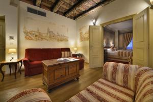 ein Wohnzimmer mit einem roten Sofa und einem Bett in der Unterkunft The Charles in Prag