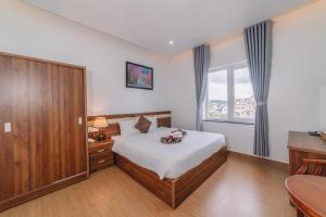 Postel nebo postele na pokoji v ubytování Anh Duc Hotel Da Lat City