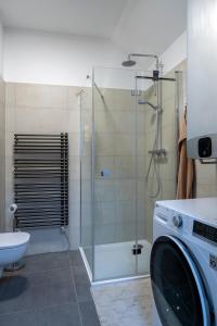 a bathroom with a shower and a washing machine at Apartmán Deštné in Deštné v Orlických horách