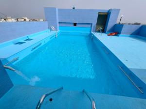 een zwembad met blauw water in een gebouw bij Hotel City Heart Shirdi in Shirdi