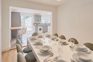 a white dining room with a table and chairs at Elfleda Stay - Modern 5 bedroom house with parking in Cambridge