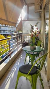- Balcón con mesa verde y silla verde en TravellerSpot_II cozy 2br apt, en Tesalónica