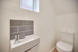 a bathroom with a sink and a toilet at Elfleda Stay - Modern 5 bedroom house with parking in Cambridge +36 photos