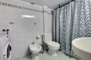 TravellerSpot_II cozy 2br apt في سلانيك: حمام ابيض مع مرحاض ومغسلة