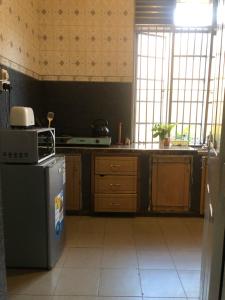 a kitchen with a stove and a refrigerator at The apartment house in Mbale