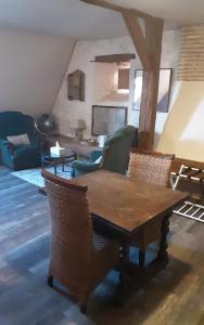 a living room with a wooden table and chairs at Val de Gée à 20 mn du circuit 24 h du Mans in Maigné