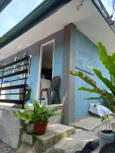 a blue house with a chair on the porch at Bohol-Simple and Elegant Suite in Tagbilaran City +3 photos