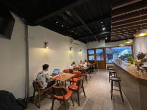 a group of people sitting at tables in a restaurant at Bông Hà Nội hostel in Hanoi