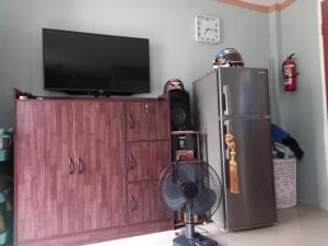 a room with a tv and a refrigerator and a fan at Bohol-Simple and Elegant Suite in Tagbilaran City